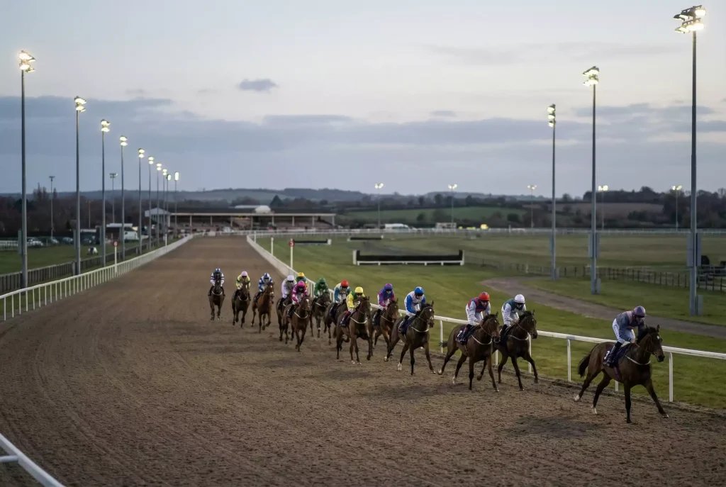 Strung-out field of horses racing over middle distance at Chelmsford City approaching the final bend